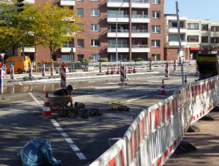 Schachtabdeckungen werden in die neue Fahrbahndecke eingebaut und auf gleiche Höhe gebracht.